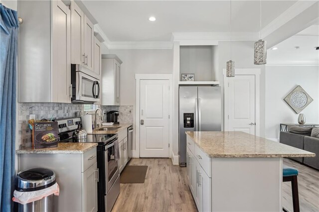 906 Sims St SW, Atlanta, GA 30603 - kitchen with a kitchen island, a kitchen bar, ornamental molding, stainless steel appliances, and a sink
