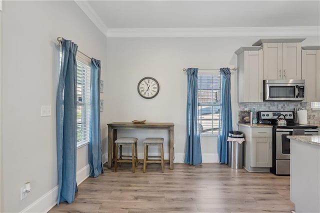 906 Sims St SW, Atlanta, GA 30603 - kitchen with tasteful backsplash, stainless steel appliances, light wood-type flooring, and ornamental molding