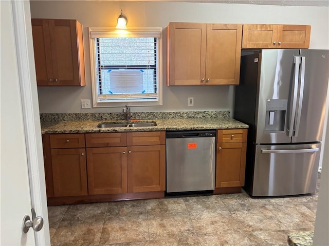 kitchen featuring light stone countertops, sink, and appliances with stainless steel finishes