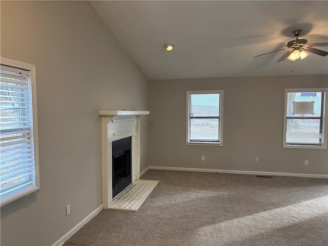 unfurnished living room with a healthy amount of sunlight, carpet floors, and vaulted ceiling