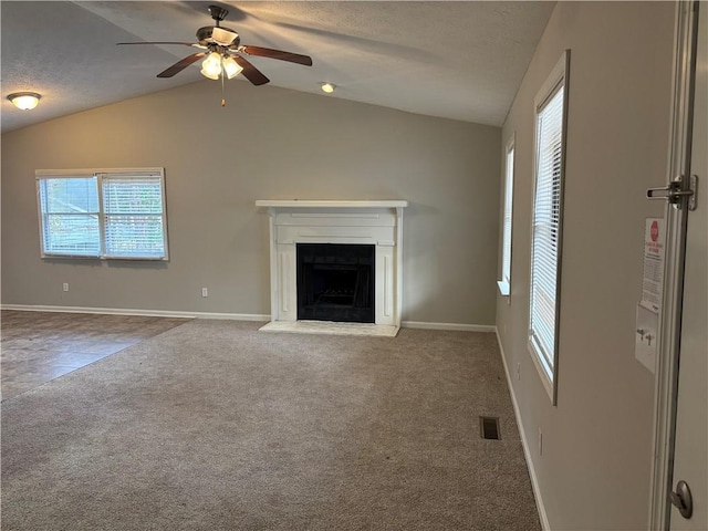 unfurnished living room with ceiling fan, carpet floors, a textured ceiling, and lofted ceiling