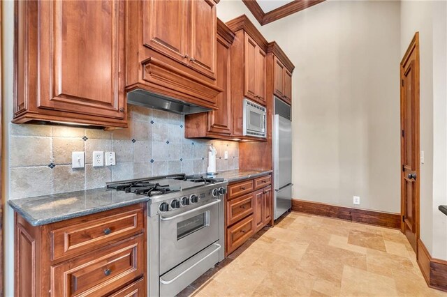 rec room featuring crown molding, stone tile floors, baseboards, a towering ceiling, and ornate columns