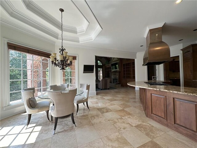 kitchen featuring a notable chandelier, tasteful backsplash, island exhaust hood, a large island with sink, and pendant lighting