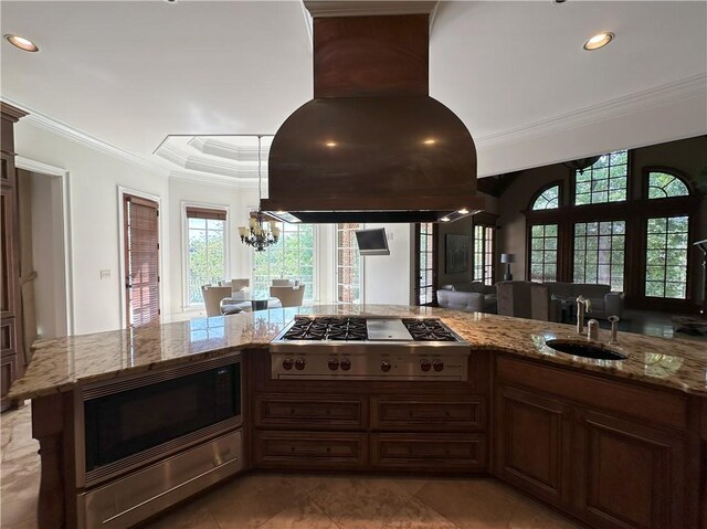 dining space with an inviting chandelier, a fireplace, a tray ceiling, and a wealth of natural light