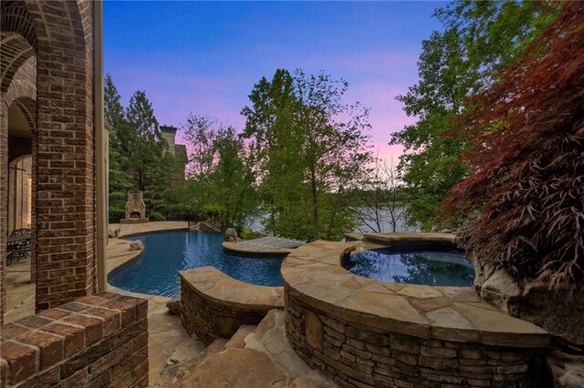 view of swimming pool featuring a patio and a fireplace