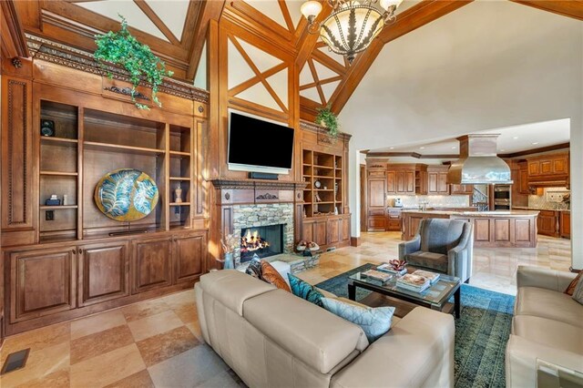 living area with an inviting chandelier, ornamental molding, wood finished floors, coffered ceiling, and beamed ceiling