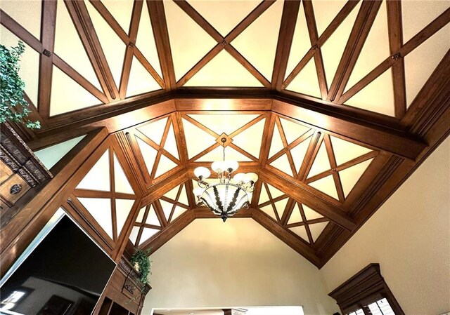 living area with visible vents, a chandelier, built in shelves, high vaulted ceiling, and a fireplace