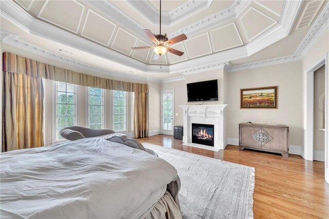 bedroom with light wood-style floors, coffered ceiling, crown molding, and ceiling fan