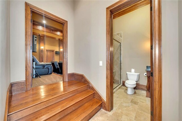 bedroom featuring a tray ceiling, light colored carpet, a ceiling fan, ornamental molding, and baseboards