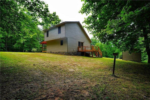 view of property exterior with a wooden deck and a yard