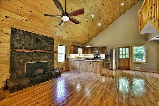 kitchen with light hardwood / wood-style floors, stainless steel appliances, kitchen peninsula, and wooden ceiling