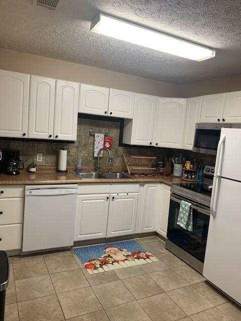 kitchen with white cabinetry, appliances with stainless steel finishes, sink, and backsplash