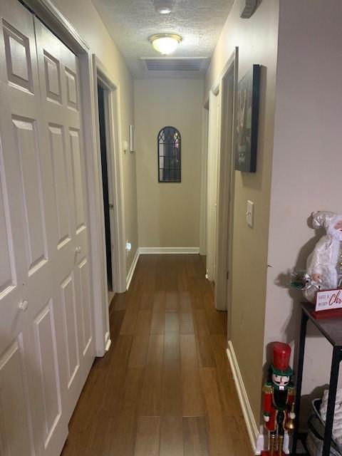 hall featuring dark hardwood / wood-style flooring and a textured ceiling