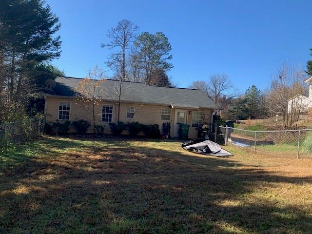 rear view of property with a lawn