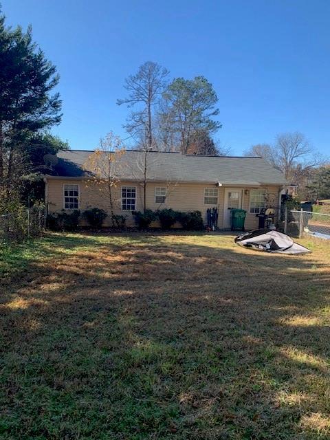 rear view of property featuring a lawn