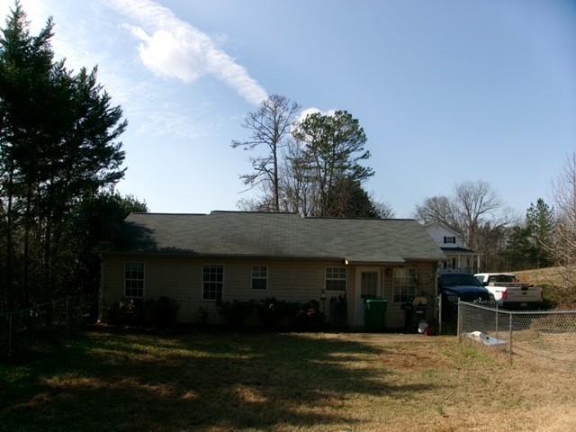 rear view of house featuring a yard