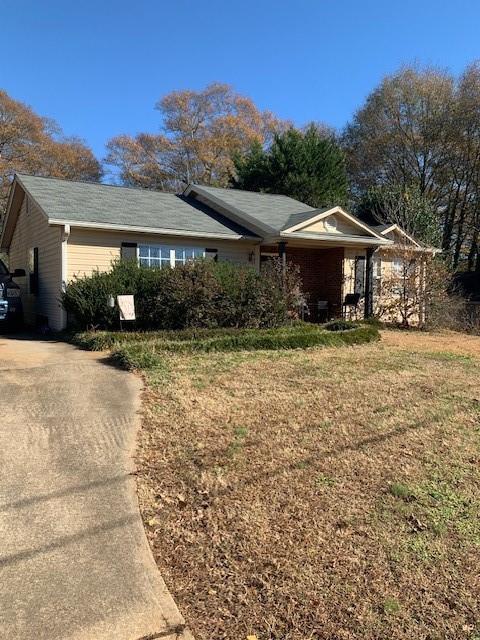 view of front of home with a carport and a front yard