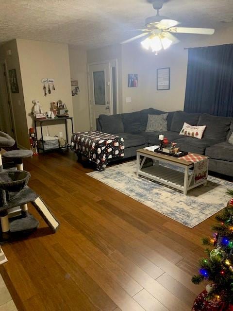 living room with hardwood / wood-style floors, a textured ceiling, and ceiling fan