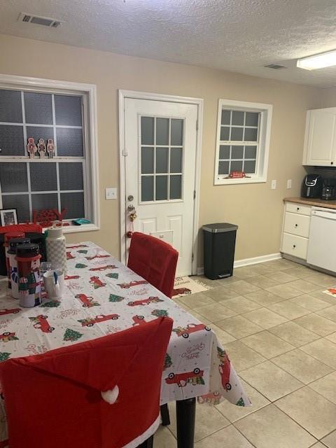 tiled dining room with a textured ceiling