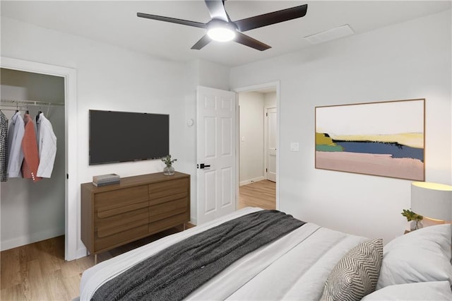 bedroom with ceiling fan, light wood-type flooring, and a closet