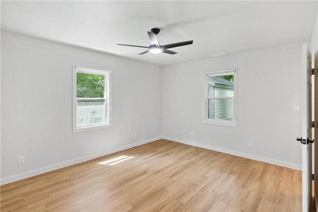 empty room with plenty of natural light, ceiling fan, and light wood-type flooring