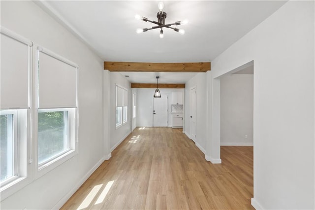 hall featuring light wood-type flooring, a notable chandelier, and beam ceiling