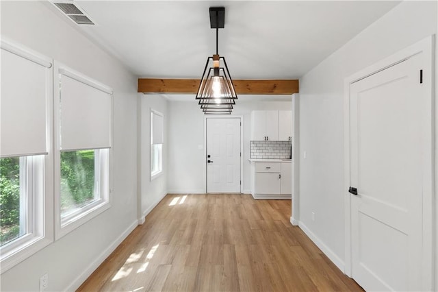 interior space featuring beam ceiling and light wood-type flooring