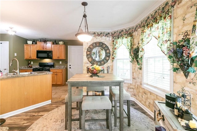 dining area featuring crown molding, baseboards, and light wood-type flooring