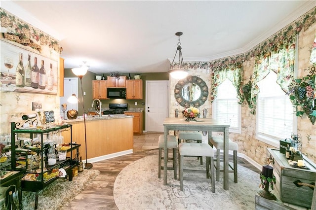 dining space featuring ornamental molding, baseboards, and light wood-style flooring