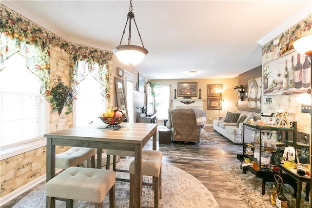 dining space featuring crown molding, wood finished floors, and baseboards