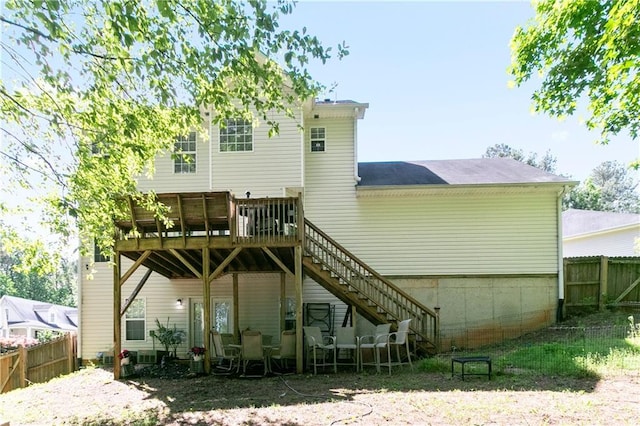 rear view of property featuring stairway, fence, and a wooden deck
