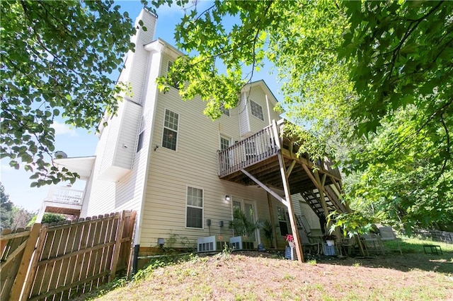 rear view of property featuring a chimney, fence, cooling unit, a deck, and stairway