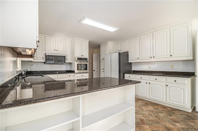 kitchen featuring appliances with stainless steel finishes, a peninsula, white cabinetry, open shelves, and a sink