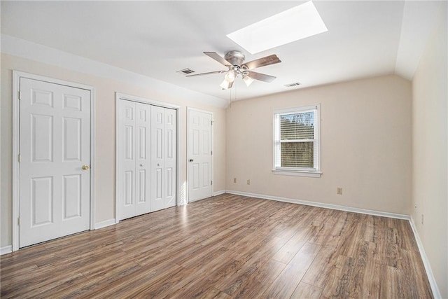 unfurnished bedroom featuring baseboards, visible vents, ceiling fan, and wood finished floors