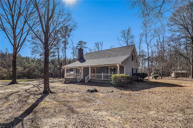 view of front of home with a chimney and a porch