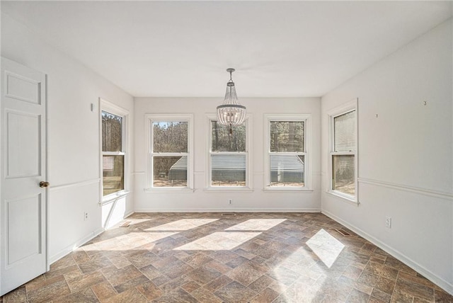 unfurnished sunroom with plenty of natural light and an inviting chandelier