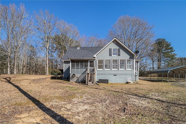 rear view of house featuring crawl space, a sunroom, and a detached carport