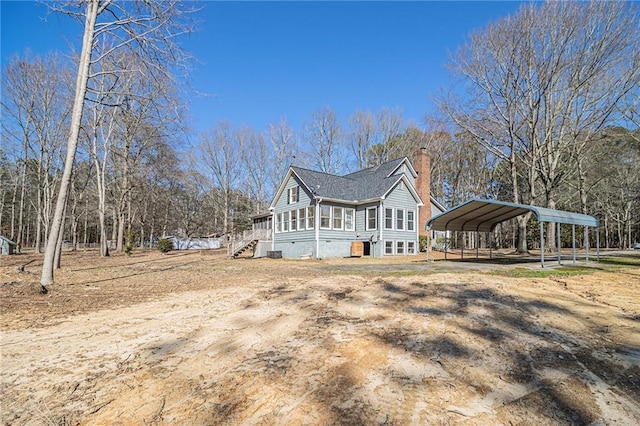 view of side of property featuring a chimney and a detached carport