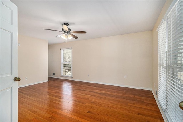 unfurnished room featuring ceiling fan, wood finished floors, and baseboards