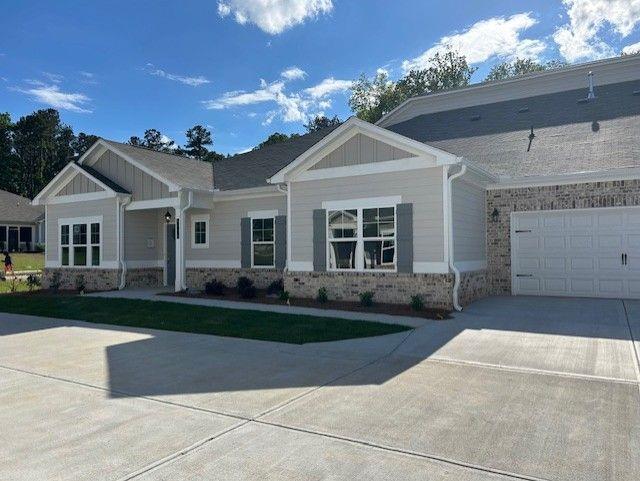 3706 Cheswolde Ave Unit 96, Powder Springs, GA 30127 - view of front facade with board and batten siding, concrete driveway, and brick siding