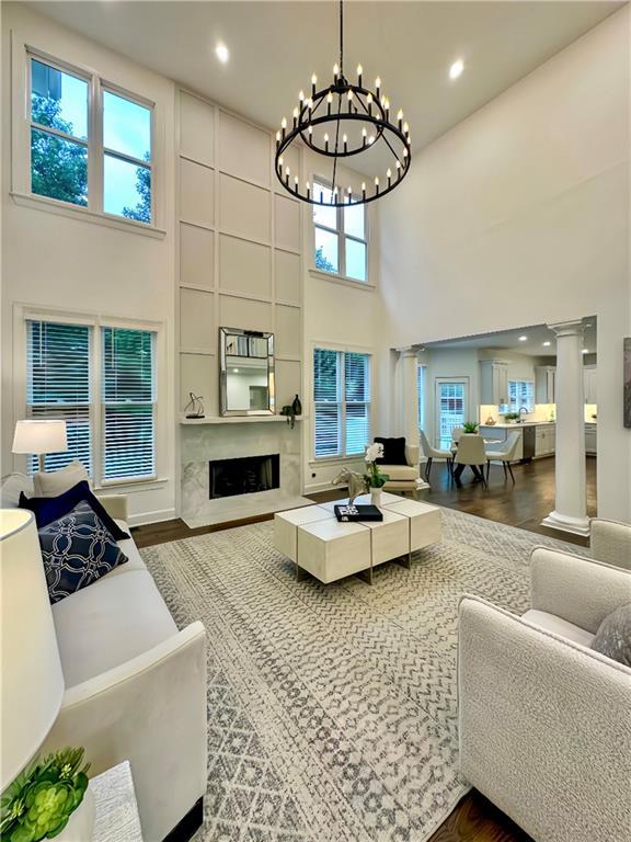 365 Morning Dew Cir, Roswell, GA 30075 - living room featuring a high ceiling, ornate columns, a chandelier, wood finished floors, and recessed lighting