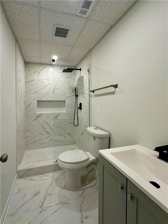 365 Morning Dew Cir, Roswell, GA 30075 - full bath with vanity, toilet, a marble finish shower, marble look tile flooring, and a paneled ceiling