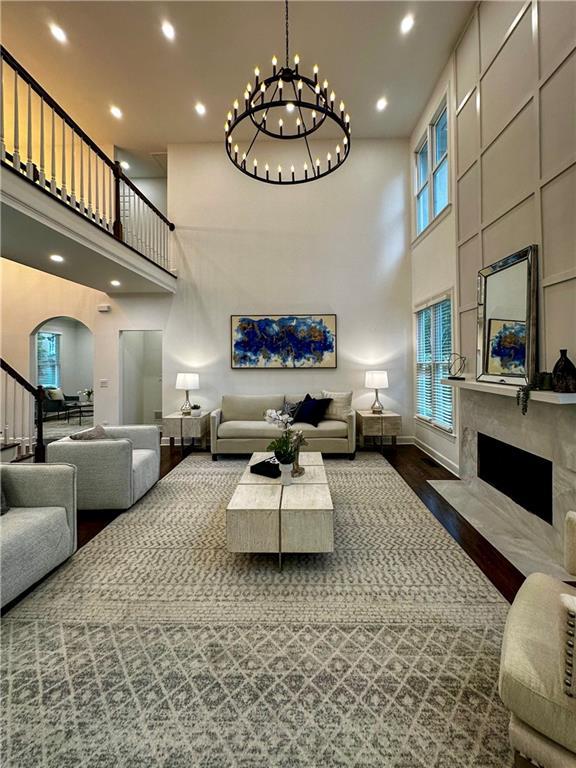 365 Morning Dew Cir, Roswell, GA 30075 - living area with a towering ceiling, arched walkways, wood finished floors, baseboards, and a high end fireplace