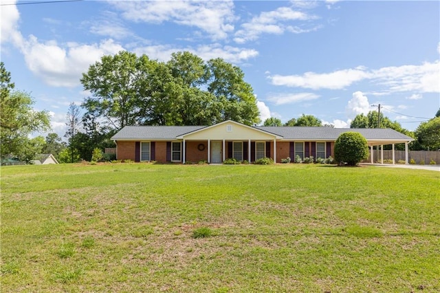 ranch-style house featuring a front lawn, brick siding, and a carport