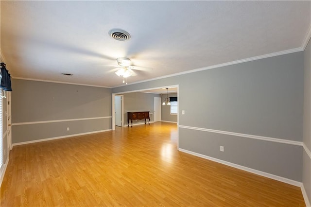 unfurnished room featuring ceiling fan, light wood-style floors, baseboards, and crown molding