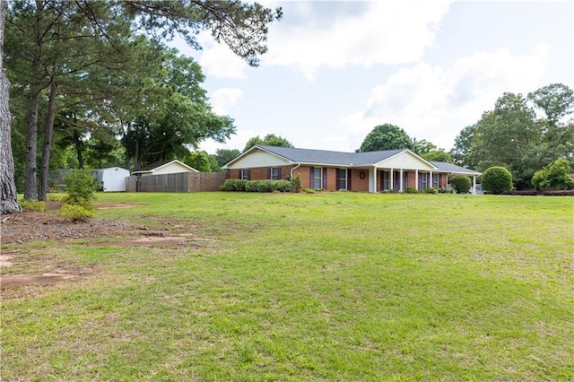 view of front of house with a shed, brick siding, and an outbuilding