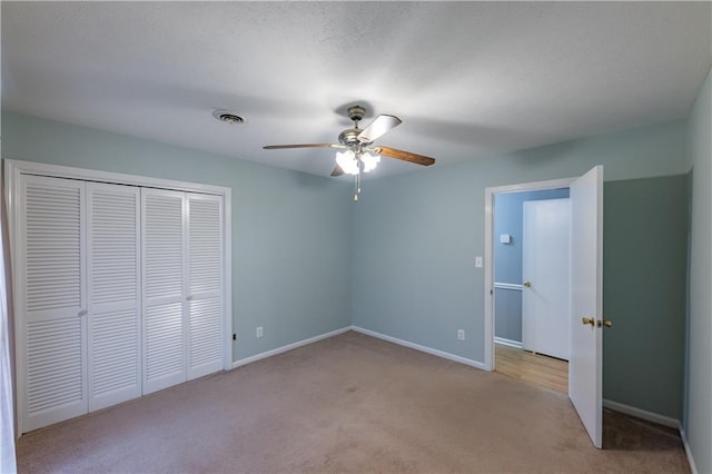 unfurnished bedroom featuring light carpet, a closet, baseboards, and a ceiling fan