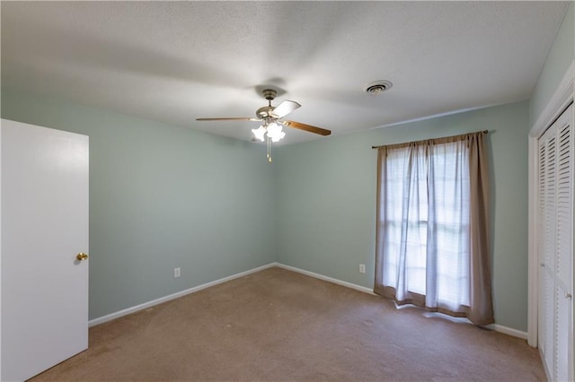 unfurnished bedroom featuring carpet floors, a closet, baseboards, and ceiling fan