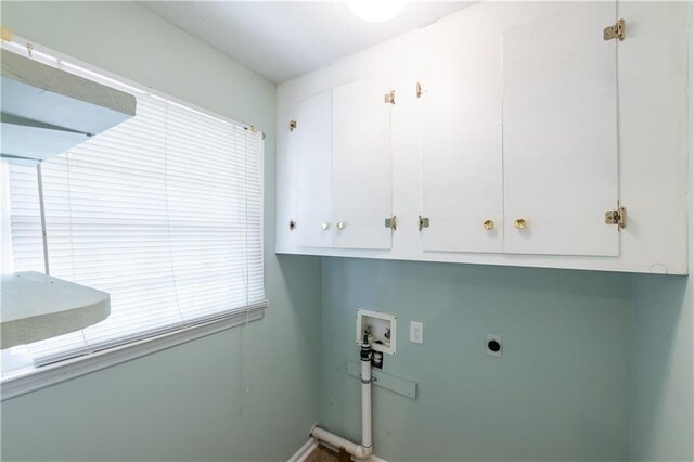 washroom with cabinet space, electric dryer hookup, hookup for a washing machine, and baseboards