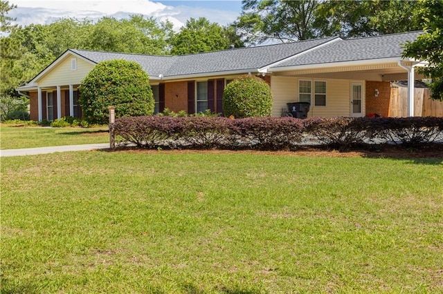single story home featuring a front yard, brick siding, and roof with shingles
